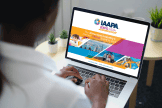 Woman looks at a laptop screen with details about IAAPA Expo Asia Virtual Conference